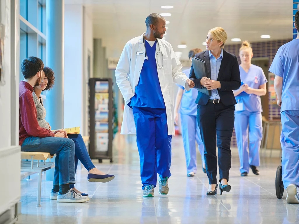 Team of experts walking down the hospital corridor; ?>