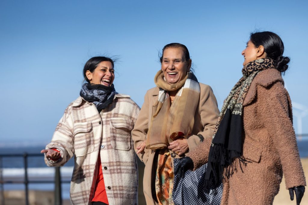 Picture of an older woman enjoying the company of her daughters outdoors