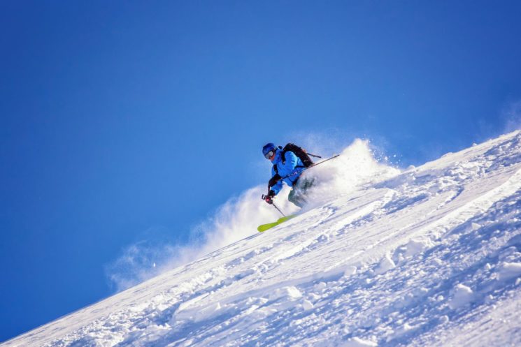 Man skiing down snow-covered slopes